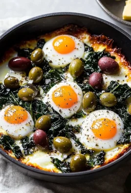 Baked eggs with chard and olives in a rustic baking dish