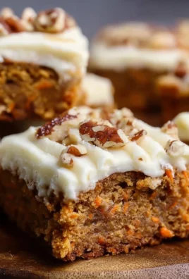 Delicious carrot cake bars topped with cream cheese frosting and nuts