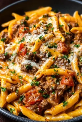 Creamy beef pasta dish garnished with herbs and served in a bowl