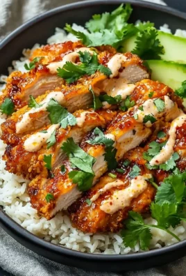 Crispy chicken topped with creamy spicy sauce garnished with herbs.