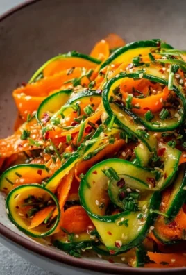 Fresh cucumber carrot salad topped with herbs, served in a bowl