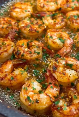 Delicious garlic butter shrimp served on a plate with herbs and lemon.