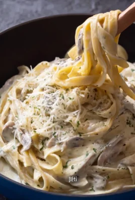 Delicious creamy Fettuccine Alfredo served in a bowl, garnished with parsley.