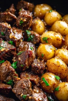 Plate of garlic butter beef bites served with roasted potatoes