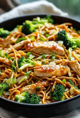 Gluten-free chicken lo mein dish garnished with vegetables