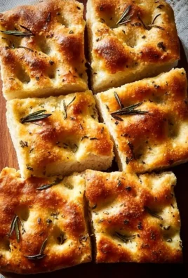 Freshly baked homemade focaccia bread topped with herbs and olive oil