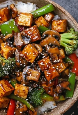 Colorful bowl of mushroom tofu stir-fry with vegetables and sauce