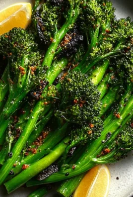 Plate of roasted broccolini garnished with lemon and garlic