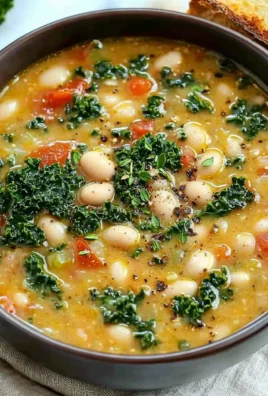 A bowl of delicious Tuscan White Bean Soup garnished with herbs and fresh vegetables.