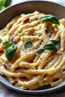 Bowl of vegan creamy pasta topped with fresh herbs and vegetables