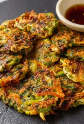 Delicious vegan vegetable pancakes topped with fresh herbs and served on a plate.