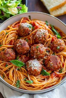 Delicious homemade spaghetti and meatballs served with fresh basil and Parmesan cheese