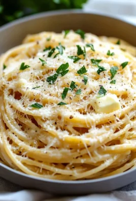 Bowl of cheesy garlic parmesan spaghetti garnished with parsley and cheese