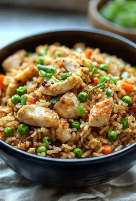 High protein crispy garlic chicken fried rice served in a bowl, garnished with green onions.