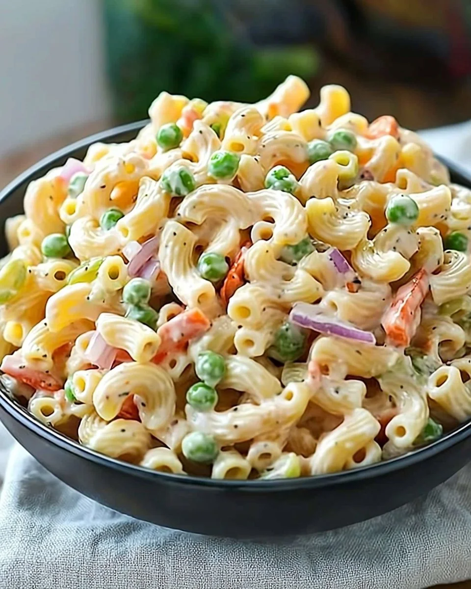 Delicious homemade Macaroni Salad served in a bowl with colorful vegetables
