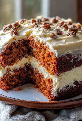 Moist homemade carrot cake with cream cheese frosting on a white plate