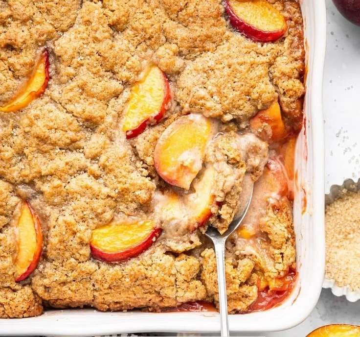 Healthy peach cobbler dessert topped with fresh peaches and wholesome ingredients
