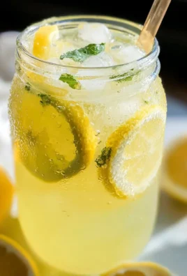 Homemade lemonade in a glass with lemon slices and mint leaves.