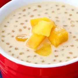 Delicious Mango Sago with Coconut Milk dessert in a bowl, garnished with mango chunks.