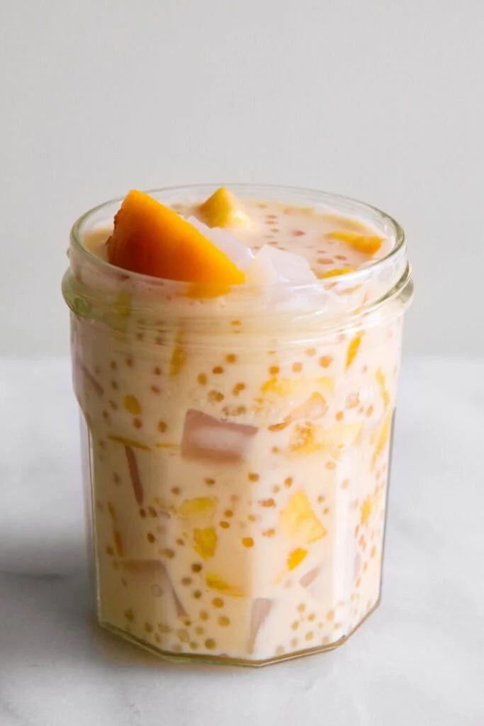 Delicious mango sago dessert topped with fresh mango chunks and coconut cream