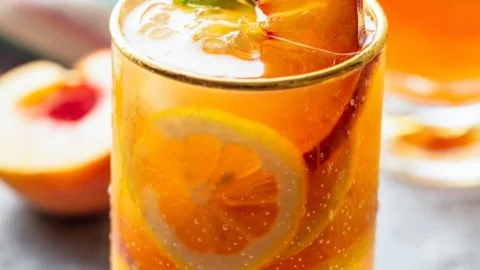 Refreshing Peach Iced Tea Lemonade in a glass with peach slices