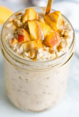 Bowl of creamy Peach Overnight Oats topped with fresh peach slices.