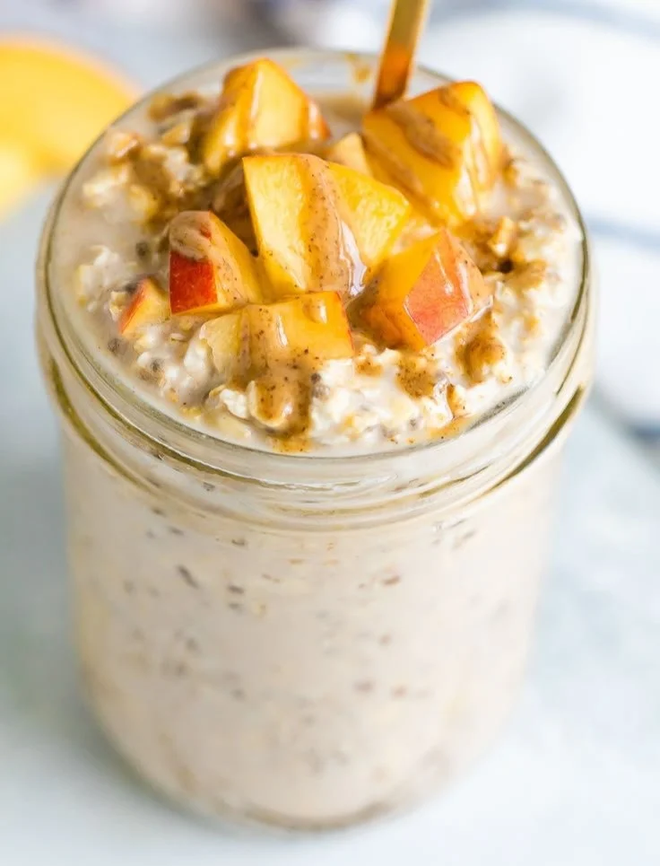 Bowl of creamy Peach Overnight Oats topped with fresh peach slices.