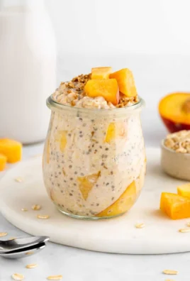 Bowl of peaches and cream overnight oats with fresh peach slices on top