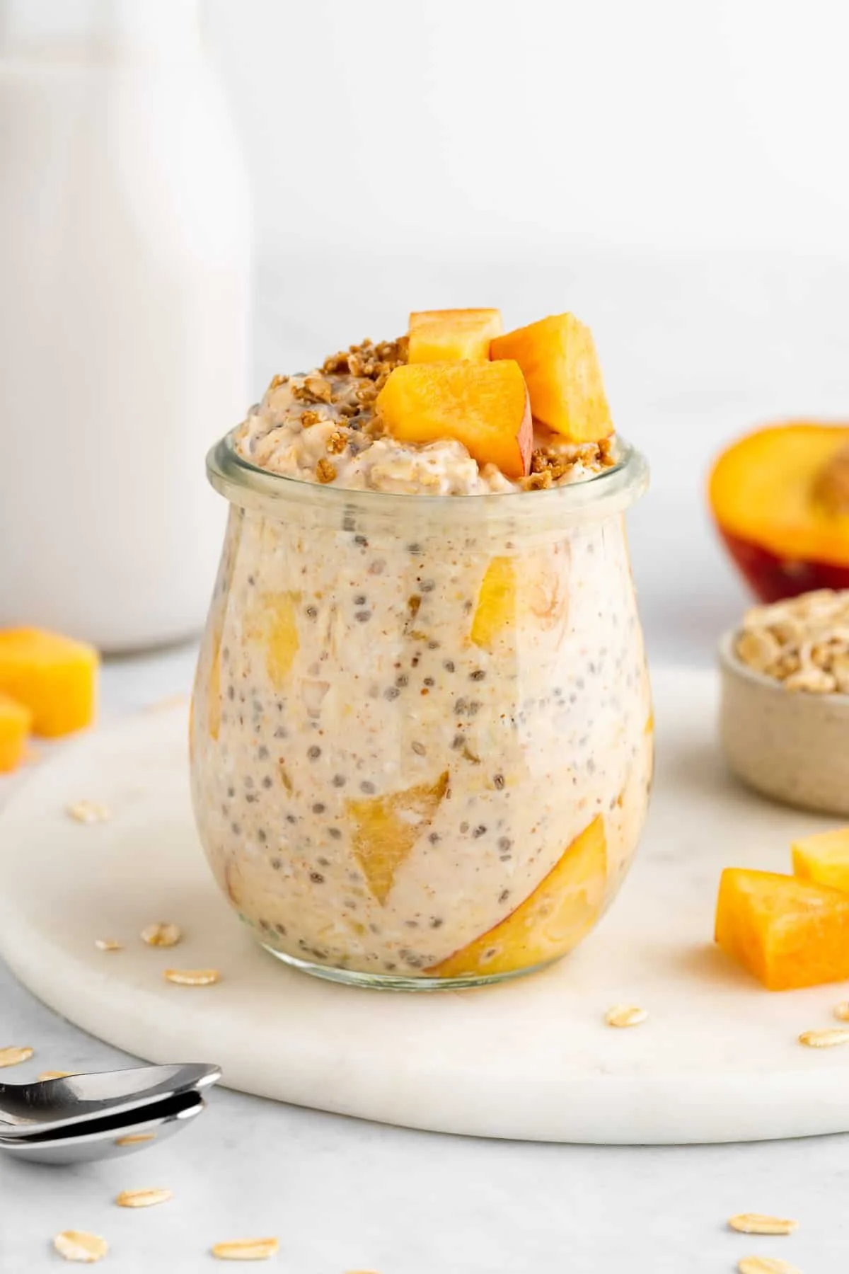 Bowl of peaches and cream overnight oats with fresh peach slices on top
