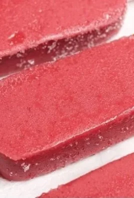Colorful protein popsicles stacked on a wooden table, healthy summer treat.