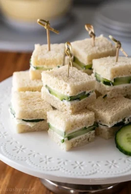 Small cucumber sandwiches served on a platter for a refreshing snack or tea party.