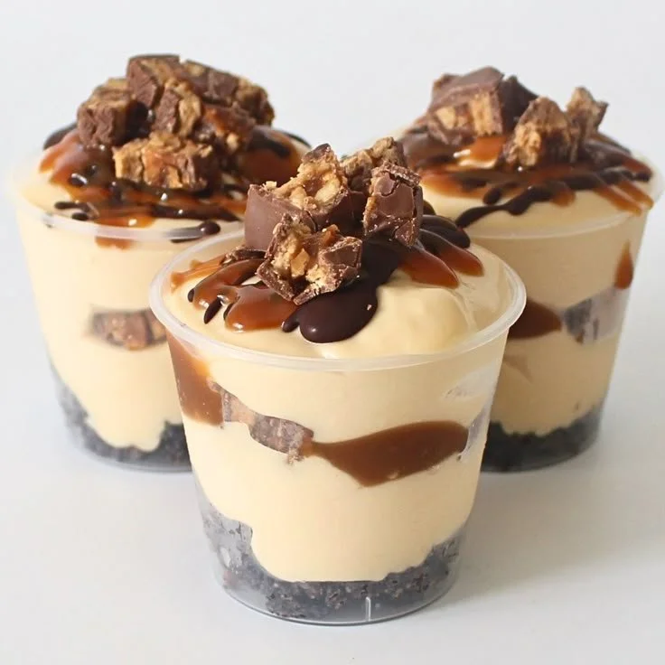 Delicious homemade Snickers Dessert Cups topped with caramel and peanuts.