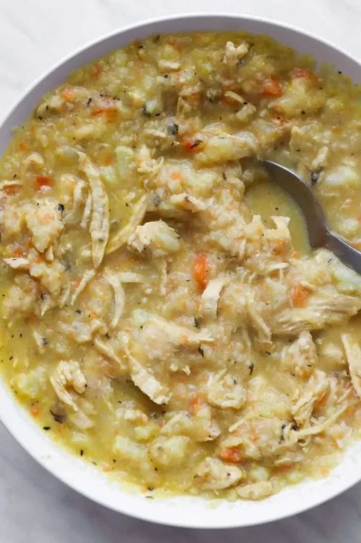 Bowl of anti-inflammatory cauliflower chicken soup garnished with herbs