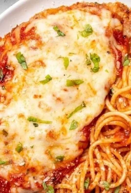 Plate of delicious Baked Chicken Parmesan topped with melted cheese and marinara sauce.