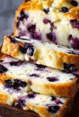 Delicious Blueberry Cream Cheese Loaf topped with fresh blueberries