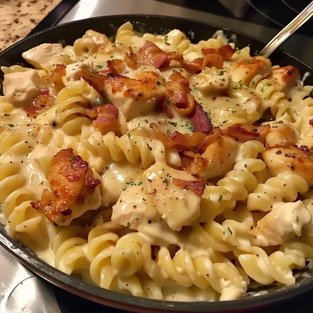 Creamy Chicken Bacon Ranch Pasta served in a bowl with bacon and herbs