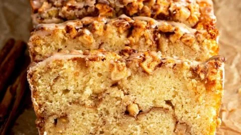 Freshly baked cinnamon apple bread with slices on a wooden board