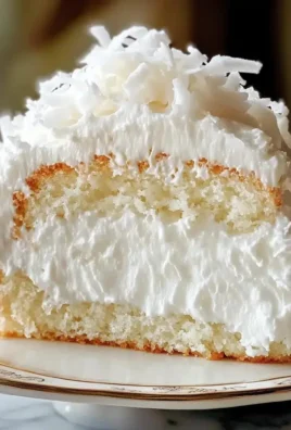 Delicious Coconut Cloud Cake served on a white plate with coconut flakes