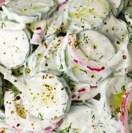 Creamy cucumber salad with fresh ingredients in a bowl