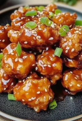 Crispy Chinese honey chicken served on a plate with colorful vegetables