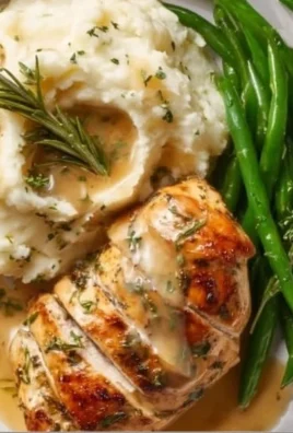 Crispy garlic herb lemon chicken garnished with fresh herbs on a plate.