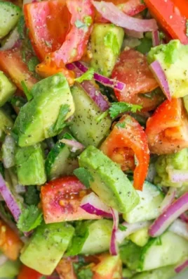 Cucumber Tomato Avocado Salad garnished with herbs in a bowl