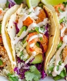 Delicious shrimp tacos garnished with fresh vegetables and lime