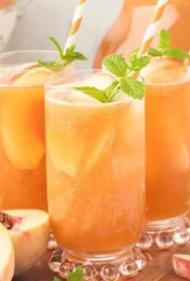 Glass of Southern Peach Tea with fresh peach slices and mint leaves