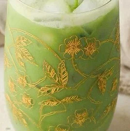 Refreshing iced matcha latte topped with milk and ice in a glass