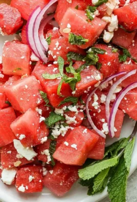 Fresh watermelon feta salad with mint leaves served in a bowl.