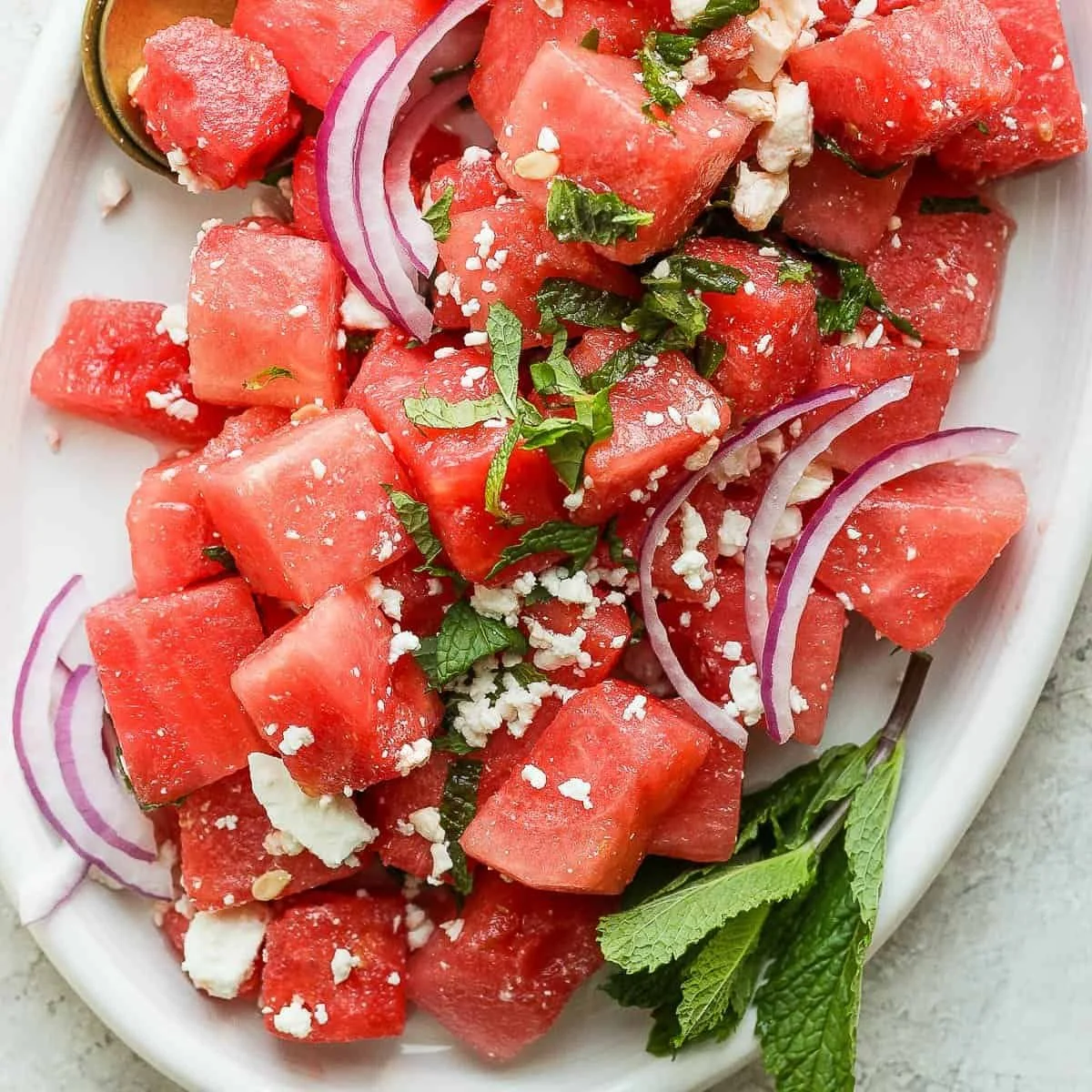 Fresh watermelon feta salad with mint leaves served in a bowl.