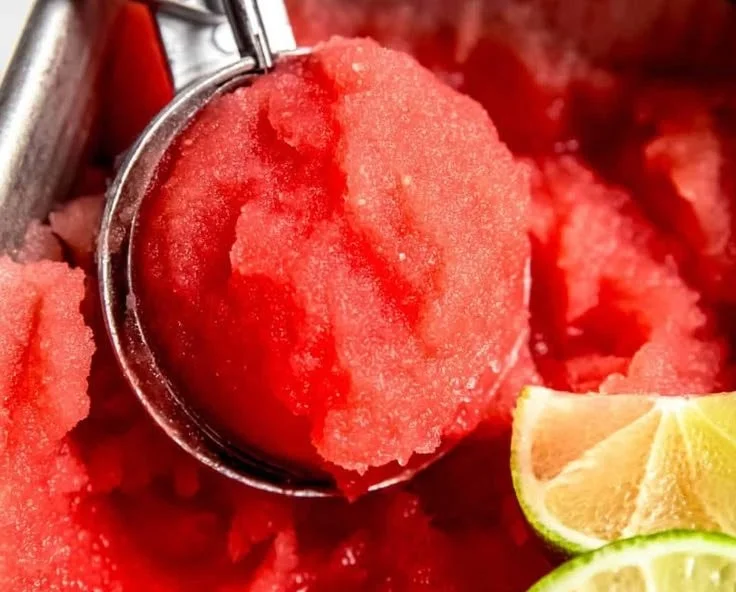 Homemade watermelon sorbet served in a bowl, garnished with mint leaves.
